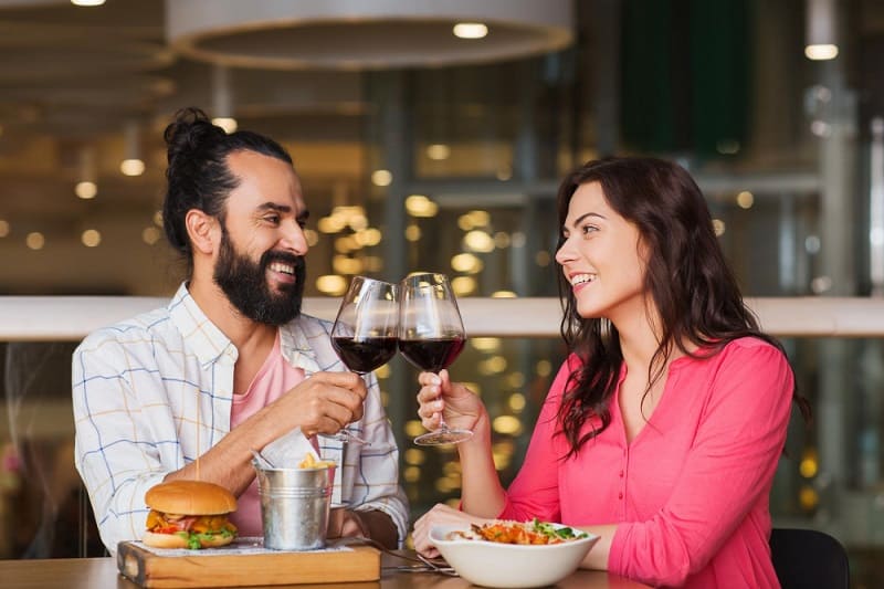 Um casal brasileiro brindando em um restaurante
