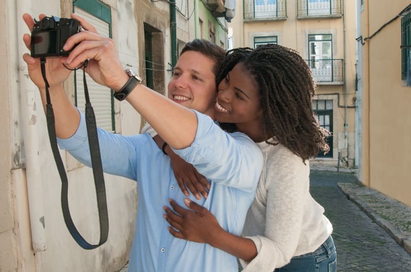Um casal interracial tirando uma selfie na rua